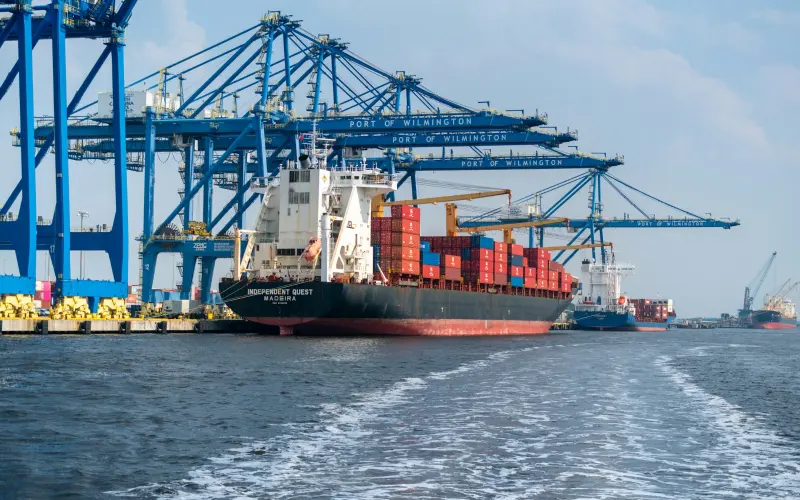 Container ship at a port with cargo cranes