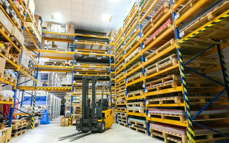 Warehouse aisles with pallets and a forklift
