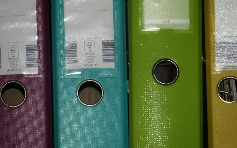 Row of colourful office binders on a shelf
