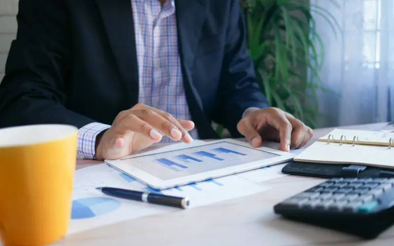 Professional reviewing financial charts on a tablet
