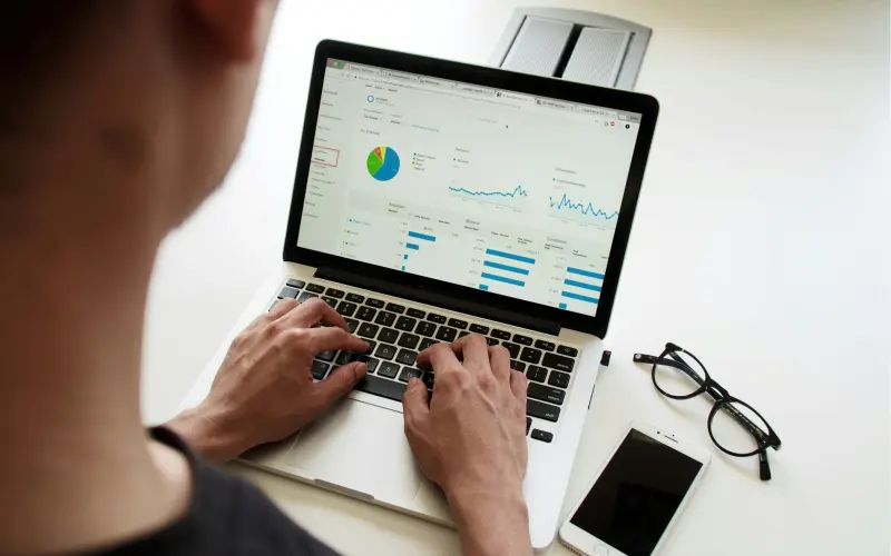 Professional reviewing finance charts on a laptop